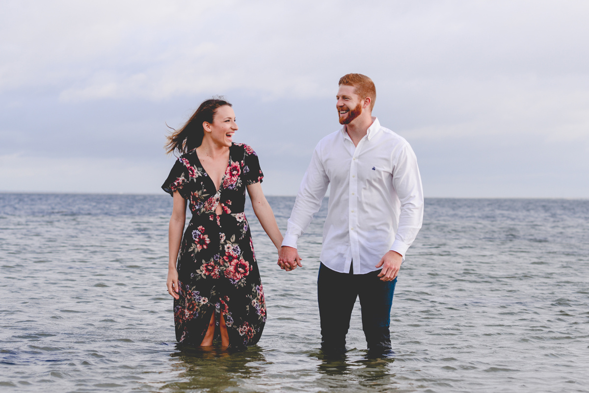 holding hands, couple, laughing, water, sky, blue, storm