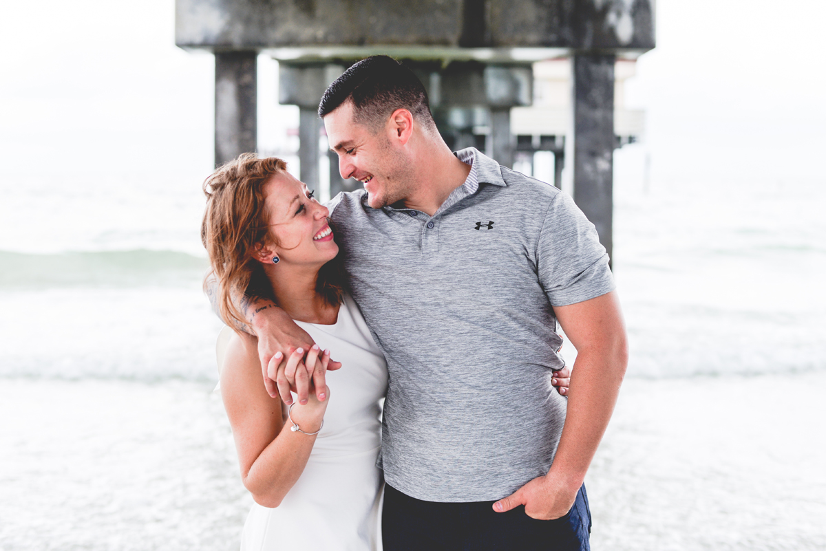 beach, pier, ocean, waves, couple, smiling 