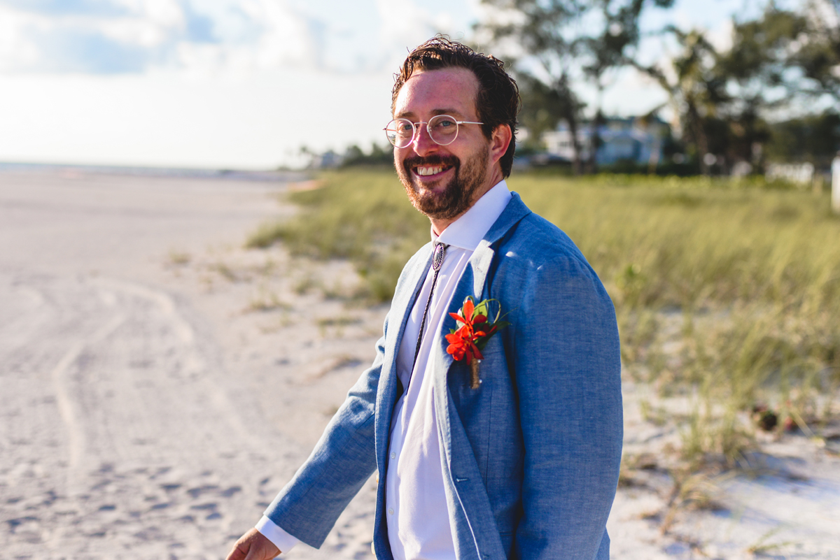 groom, beach, sand, walking, smiling, wedding