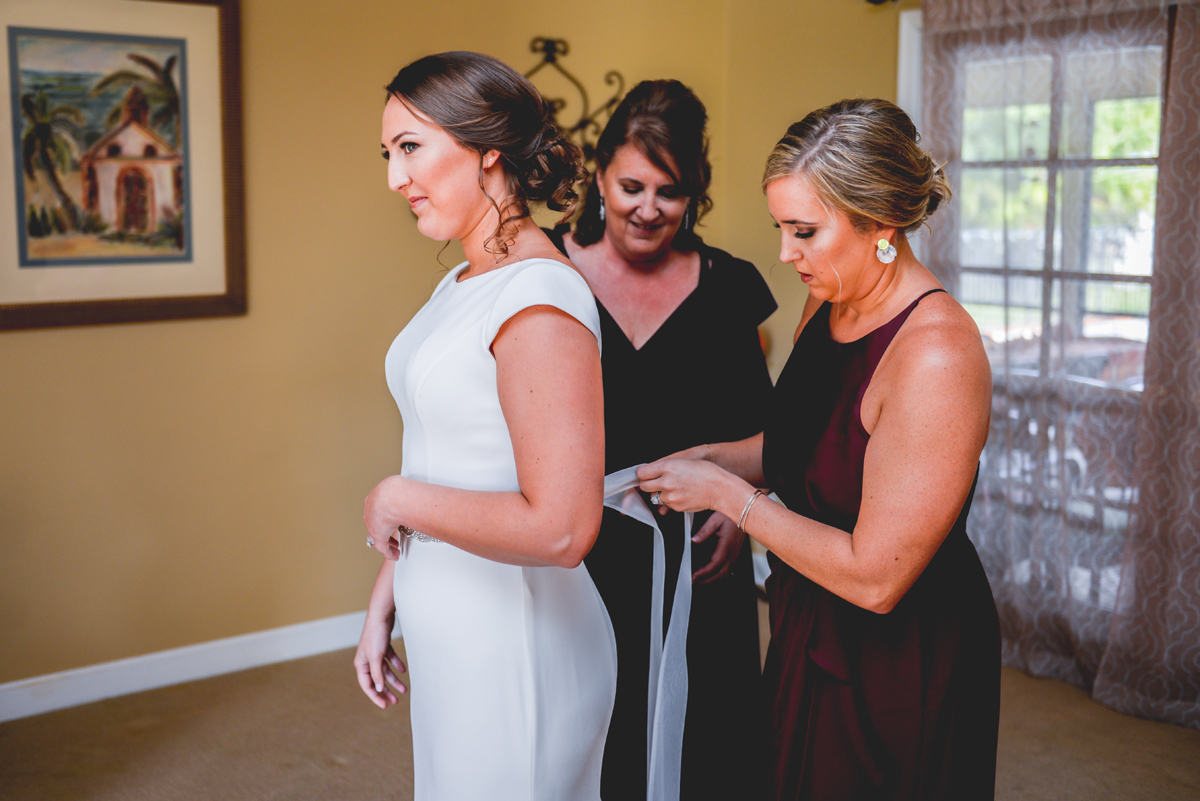 bride, getting ready, wedding dress, sister, mom, tying